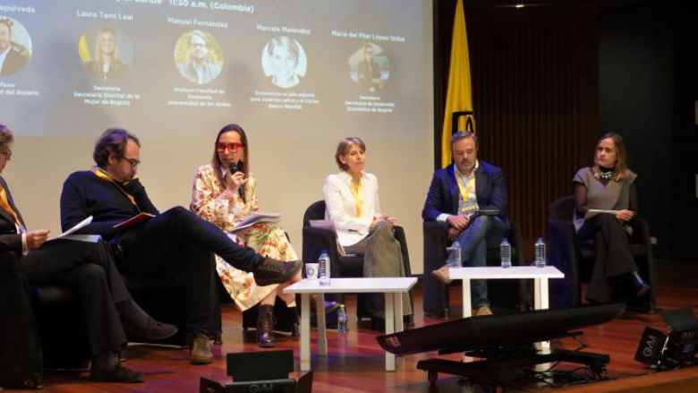 Policy research roundtable. Six participants have a discussion on a stage at an event.